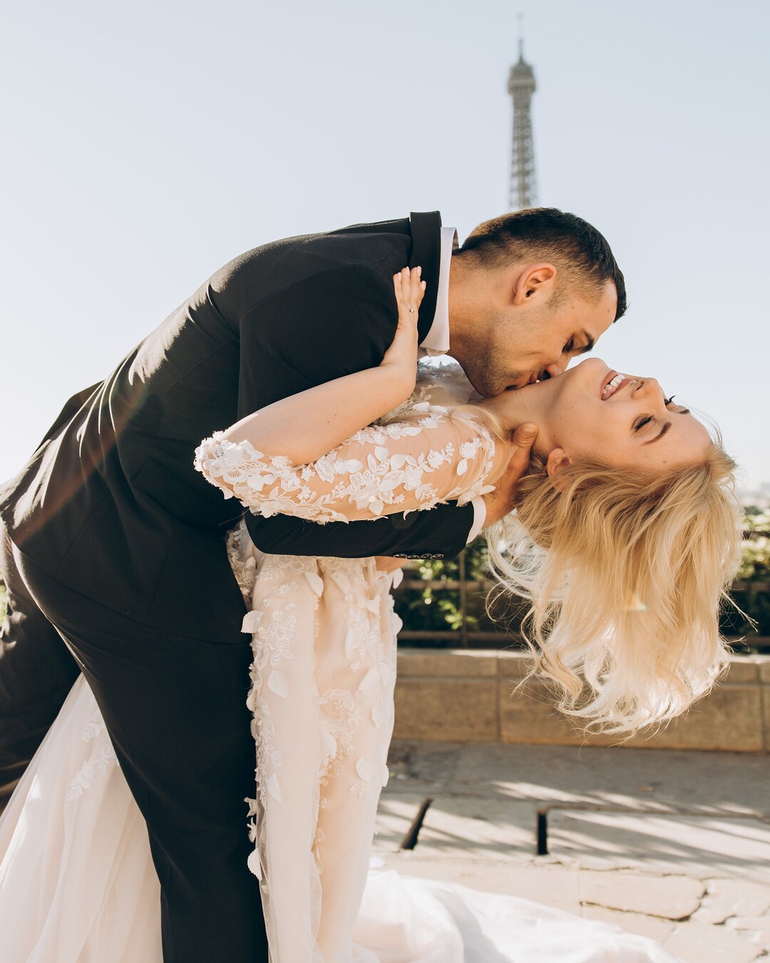 Couple de mariés s’embrassant devant la tour Eiffel lors d’un mariage à Paris